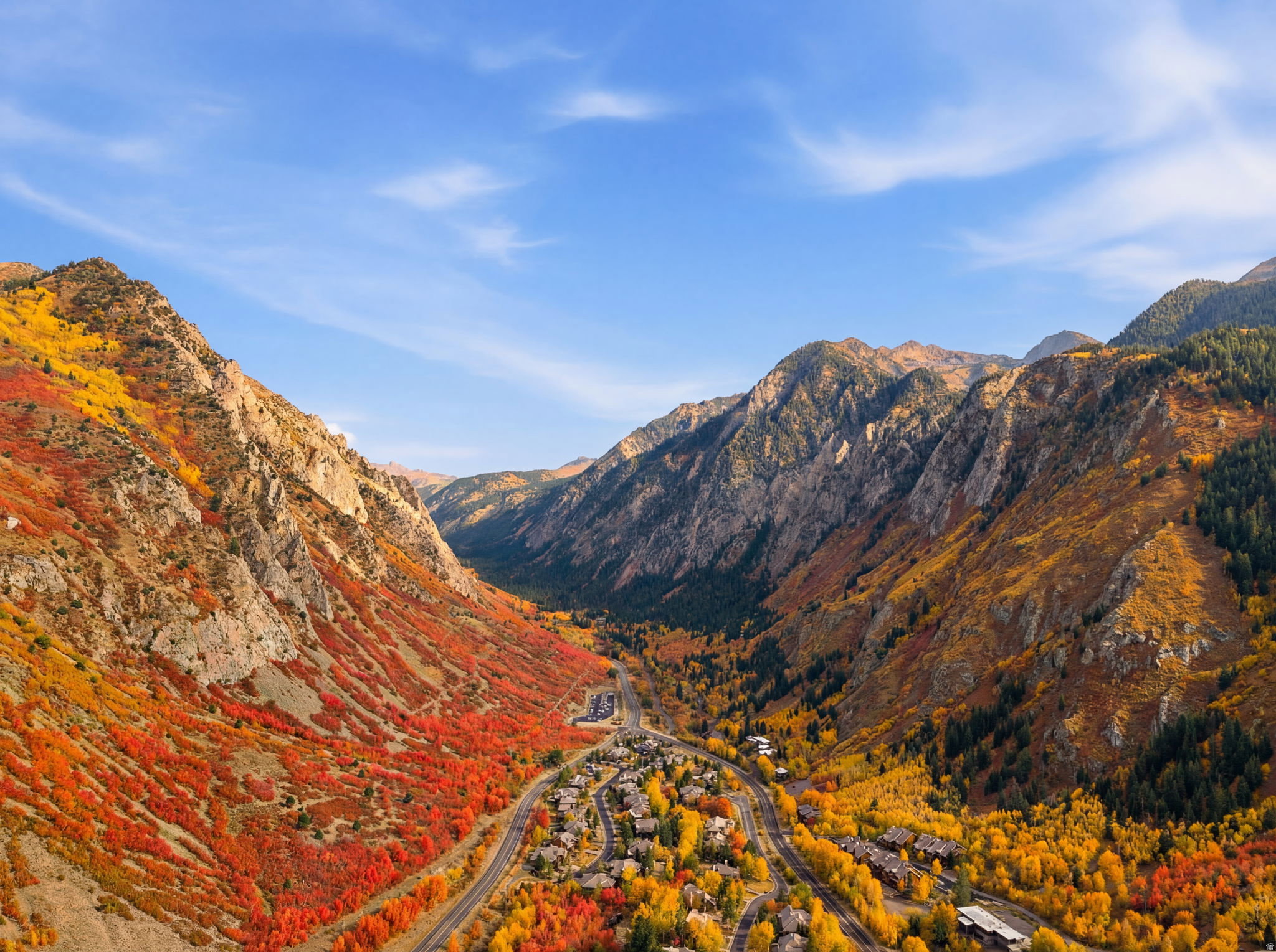 Mountainous landscape featuring a valley community with residential structures