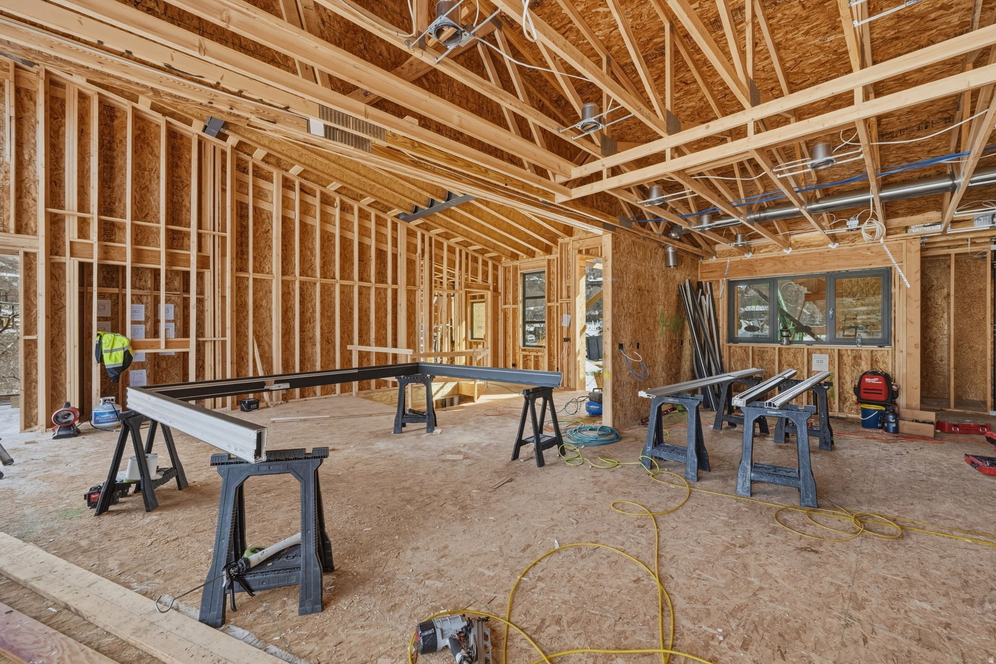 Open-concept interior framing with exposed wood trusses and structural elements