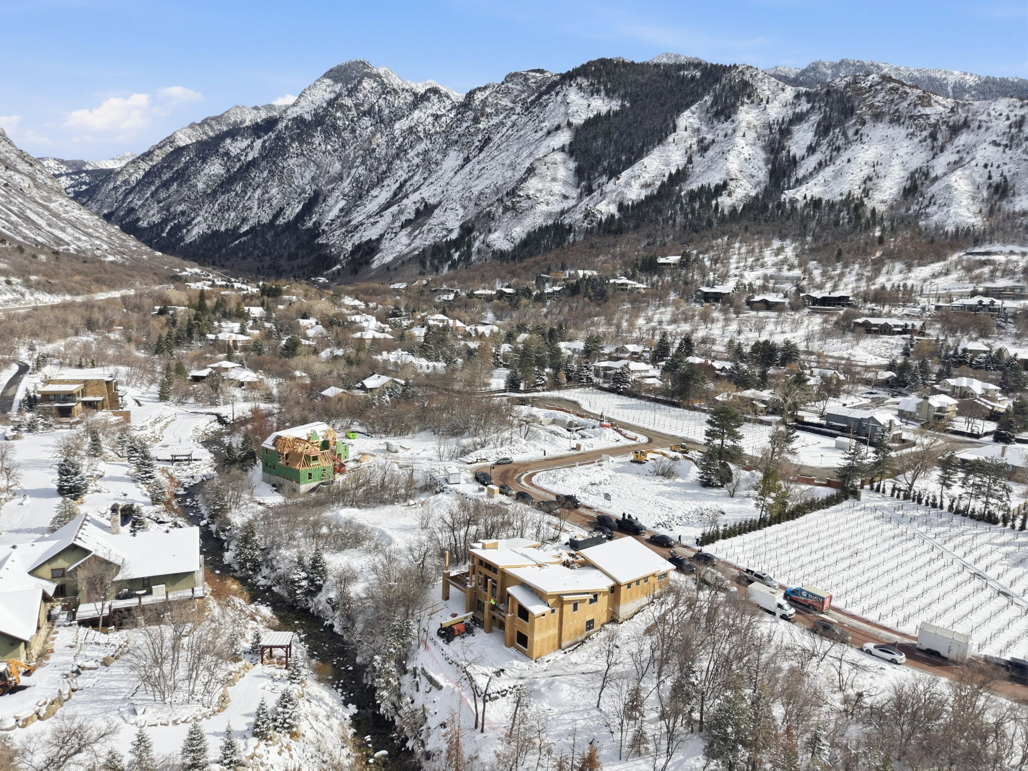Mountainous terrain with snow-covered peaks surrounds a residential area