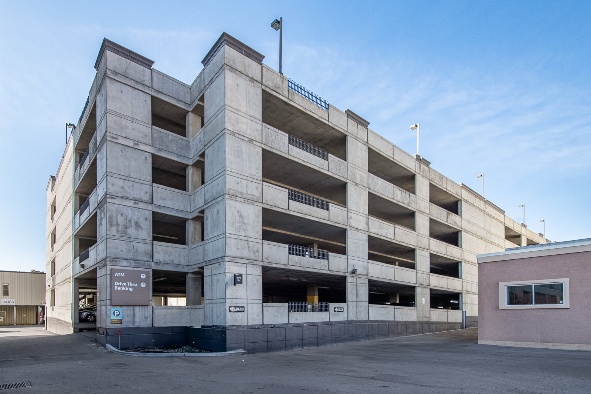 Multi-level concrete parking structure featuring multiple open-air levels and integrated lighting