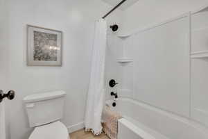 White acrylic bathtub and shower combination with dark bronze fixtures