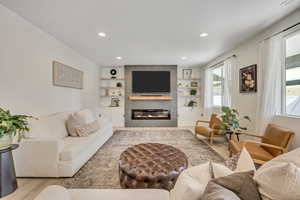Living area featuring light wood-finish flooring and recessed lighting