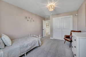 Neutral-toned room featuring a decorative overhead light fixture and light-colored carpeting