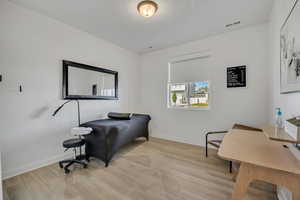 Versatile room with light wood-finish flooring and neutral wall finishes