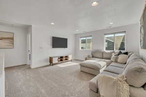Spacious upper-level room featuring neutral-toned carpeting, white painted walls, and recessed lighting