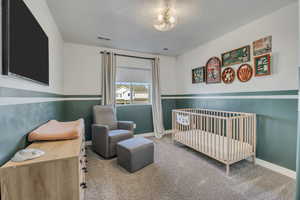 Room featuring neutral carpet flooring and a two-tone wall treatment with a dark green lower portion and white upper portion