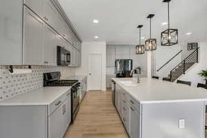 Modern kitchen featuring an expansive island with an undermount sink and brass-finish faucet