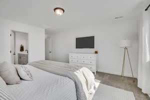 Bedroom featuring light-colored carpeting and white walls