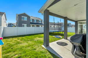 Covered concrete patio with recessed lighting, offering exterior access via a glass sliding door