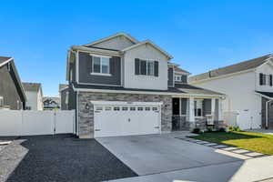 Two-story residence featuring a combination of stone veneer, dark siding, and light shaker siding
