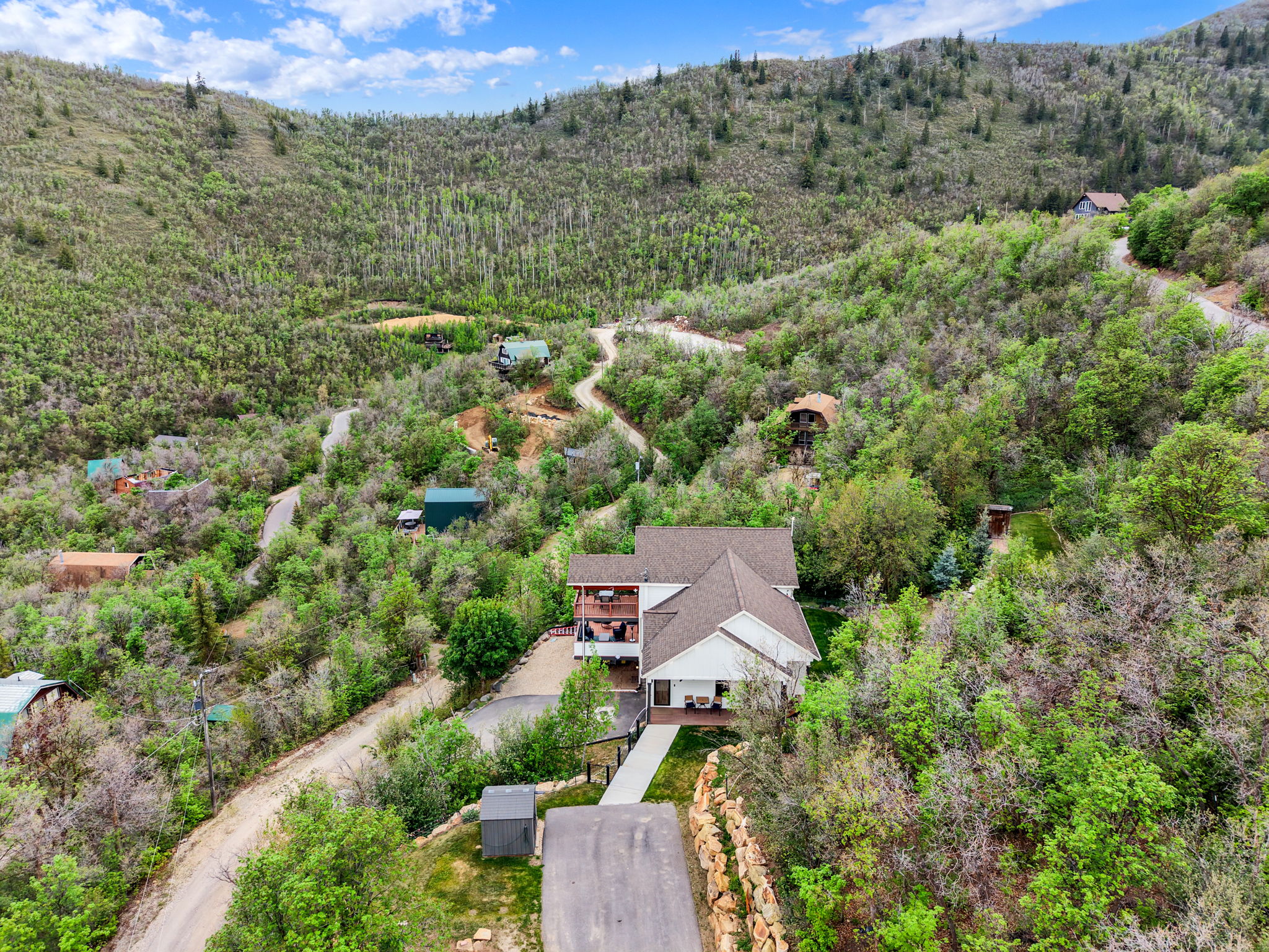Contemporary-style residence with a multi-level design nestled within a verdant, mountainous landscape