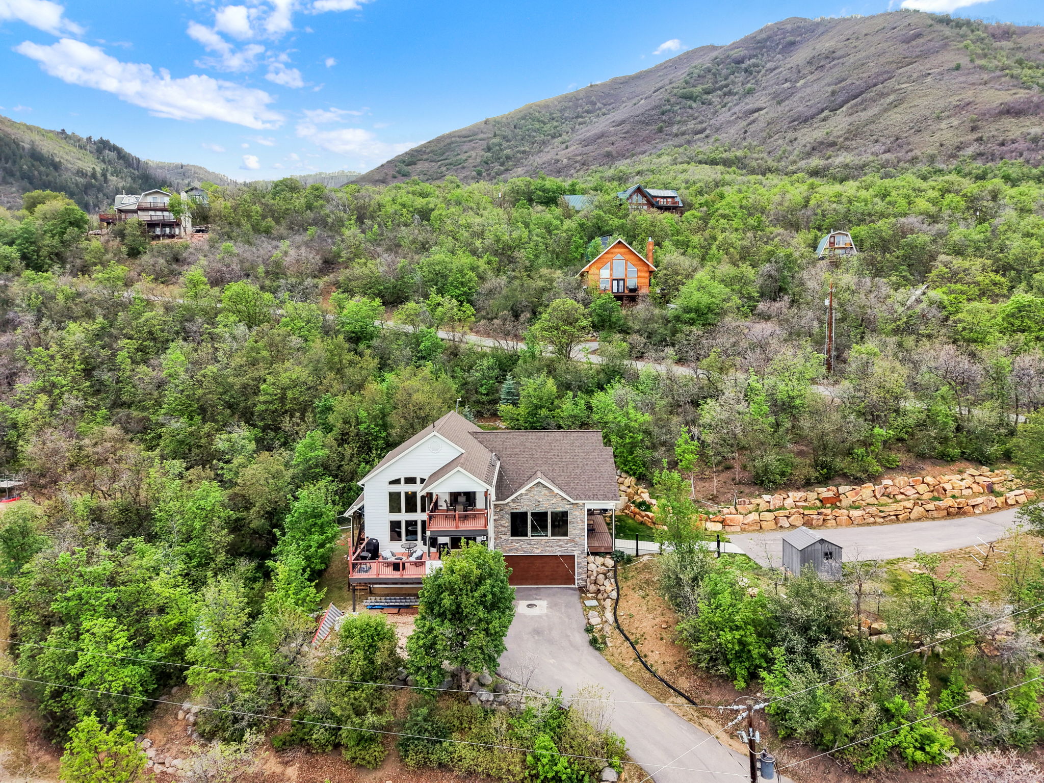 Modern mountain-style residence featuring a stone and siding exterior