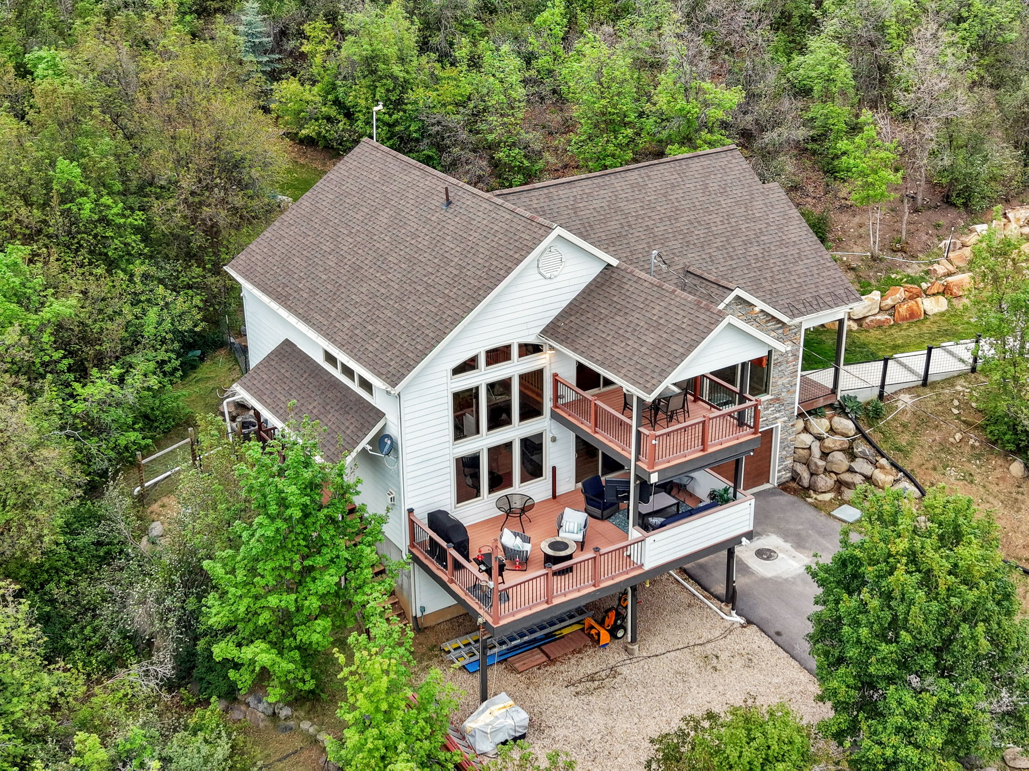 Multi-level residence featuring white siding and stone accents