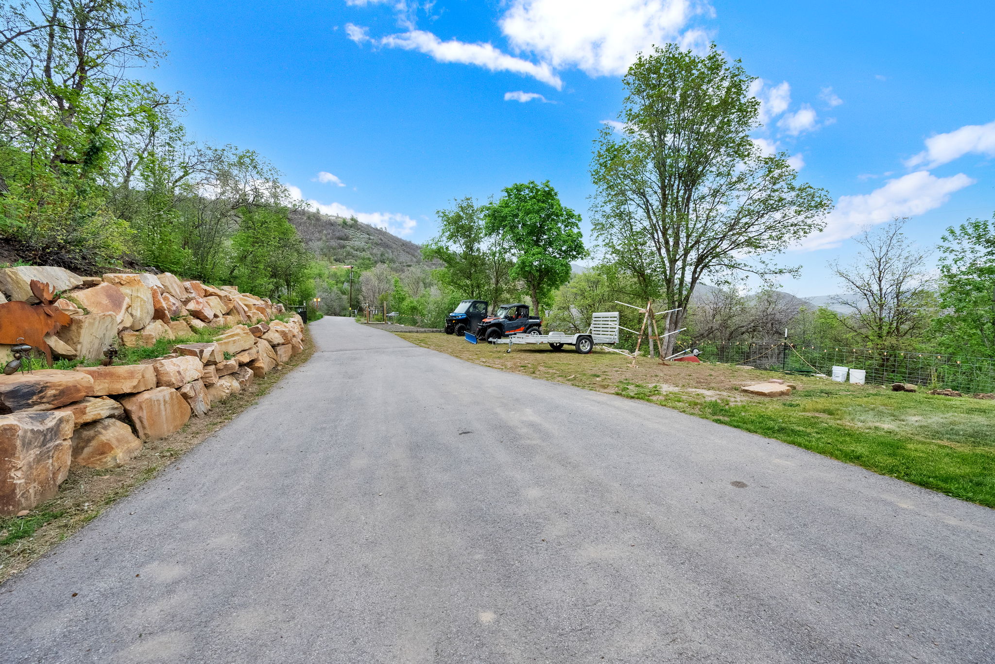 Paved driveway bordered by a natural stone retaining wall