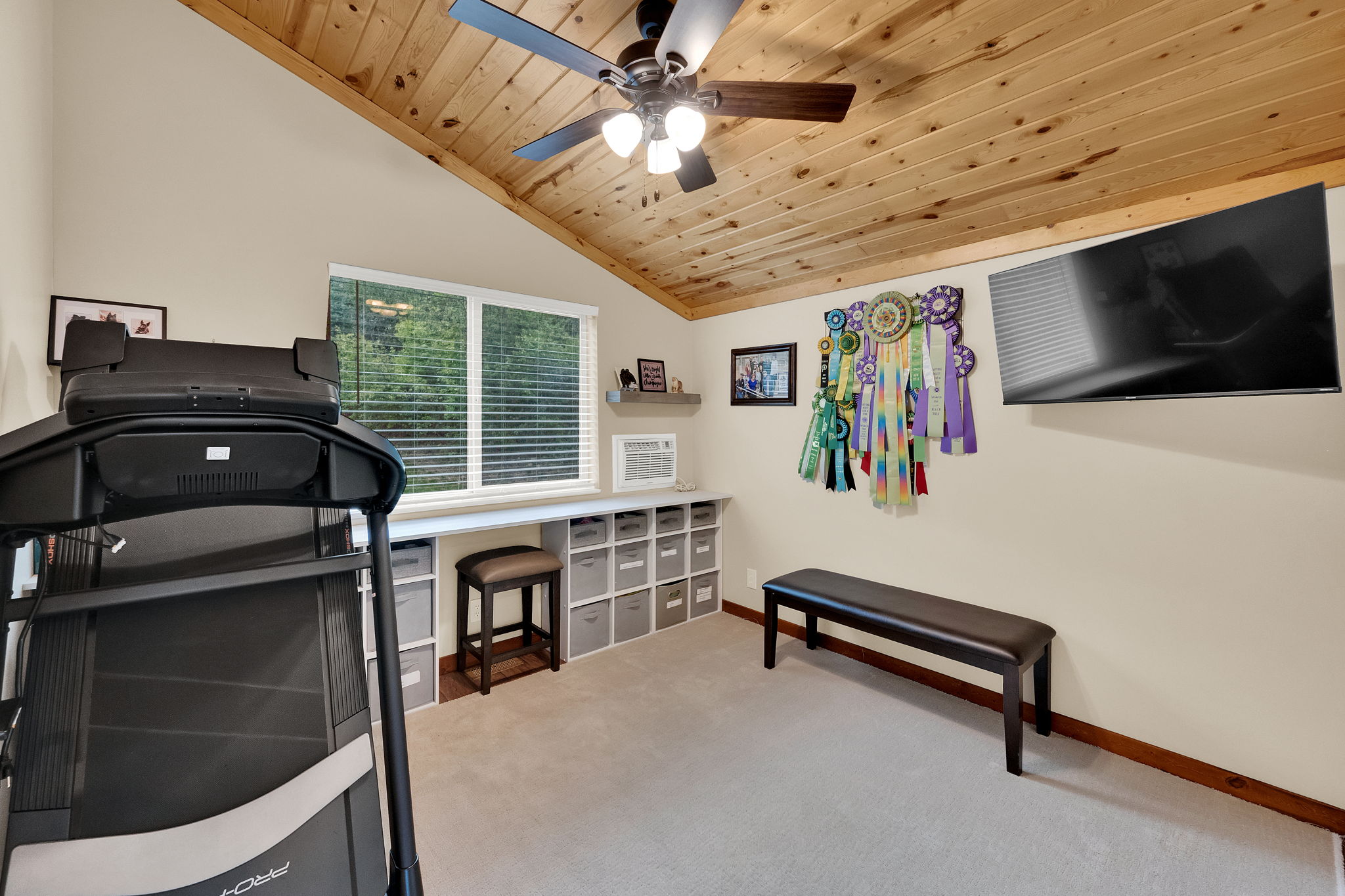 Vaulted wood-paneled ceiling featuring a ceiling fan with integrated lighting