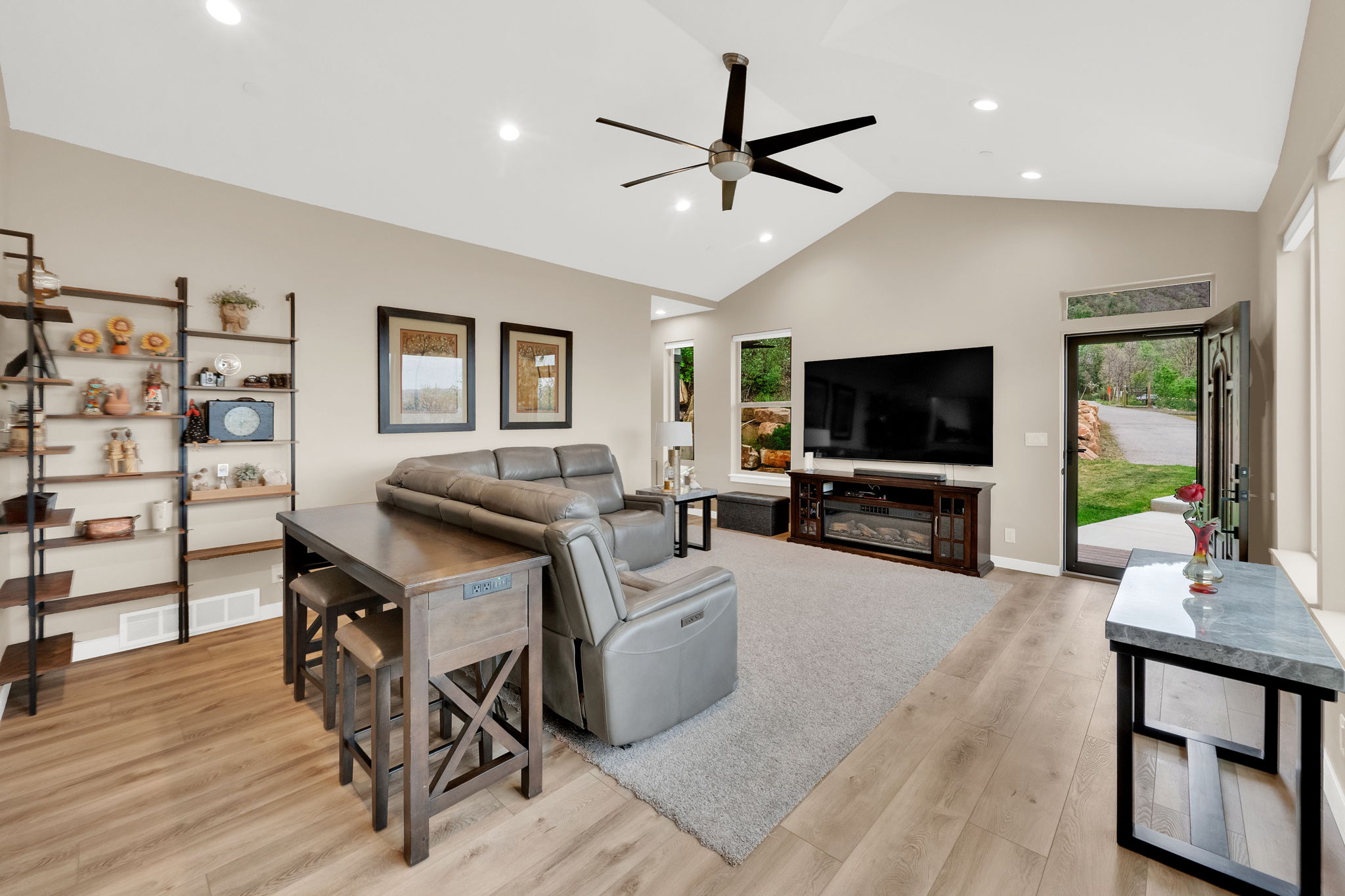 Spacious living area featuring vaulted ceilings, recessed lighting, and wood-finish flooring
