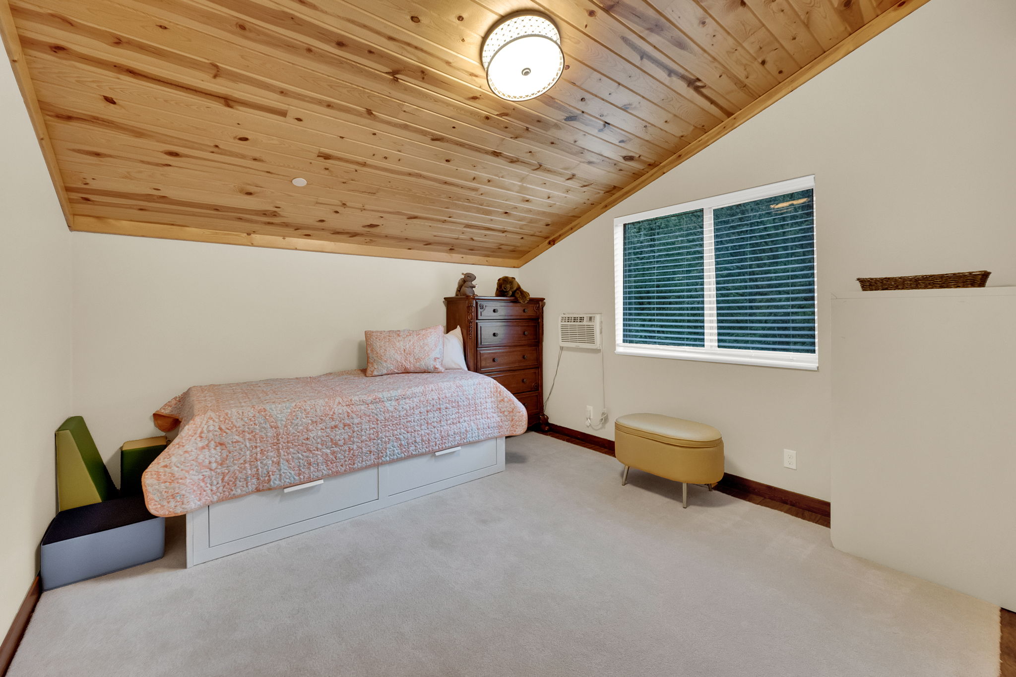 Vaulted wood-finish ceiling with recessed lighting and a central flush mount fixture