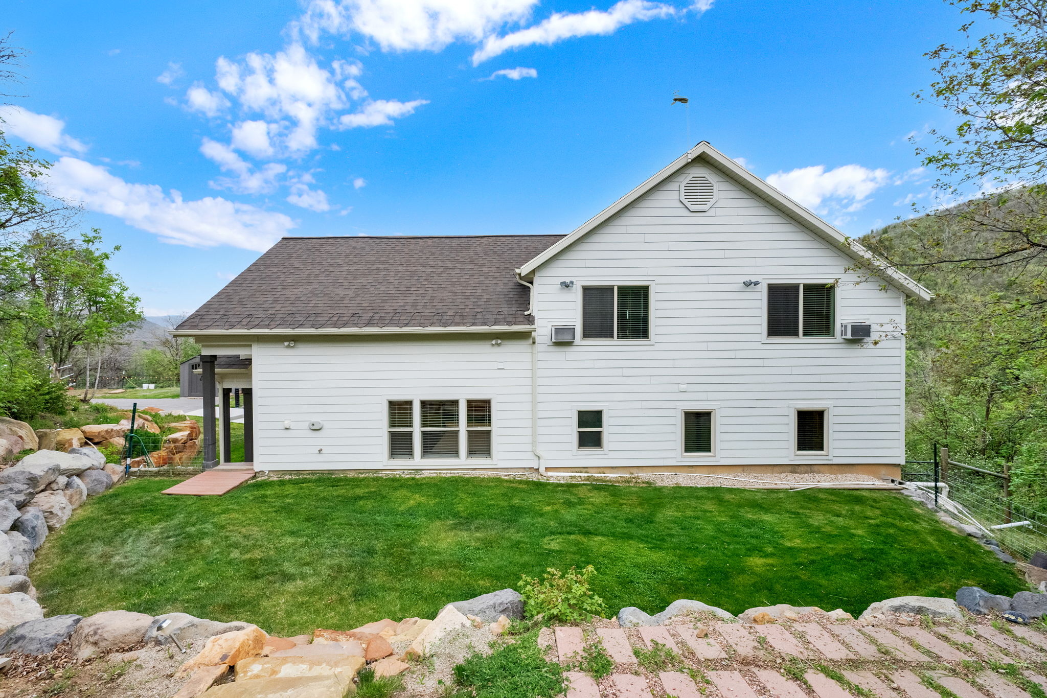 White siding exterior with a dark asphalt shingle roof