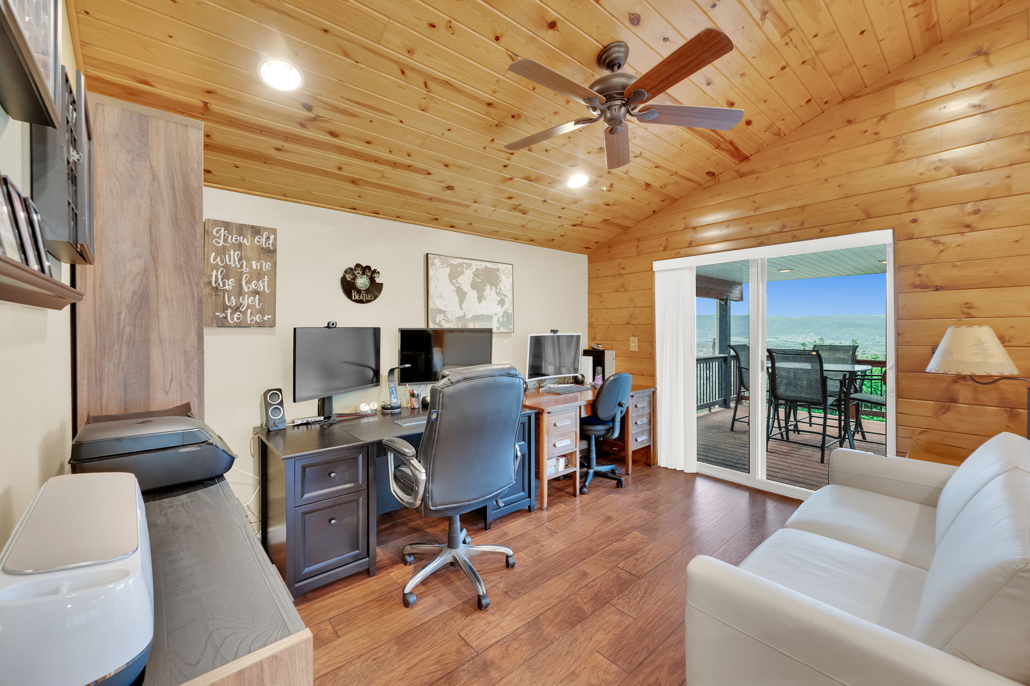 Vaulted wood-paneled ceiling with a ceiling fan, wood-finish flooring, and a sliding glass door leading to an outdoor deck