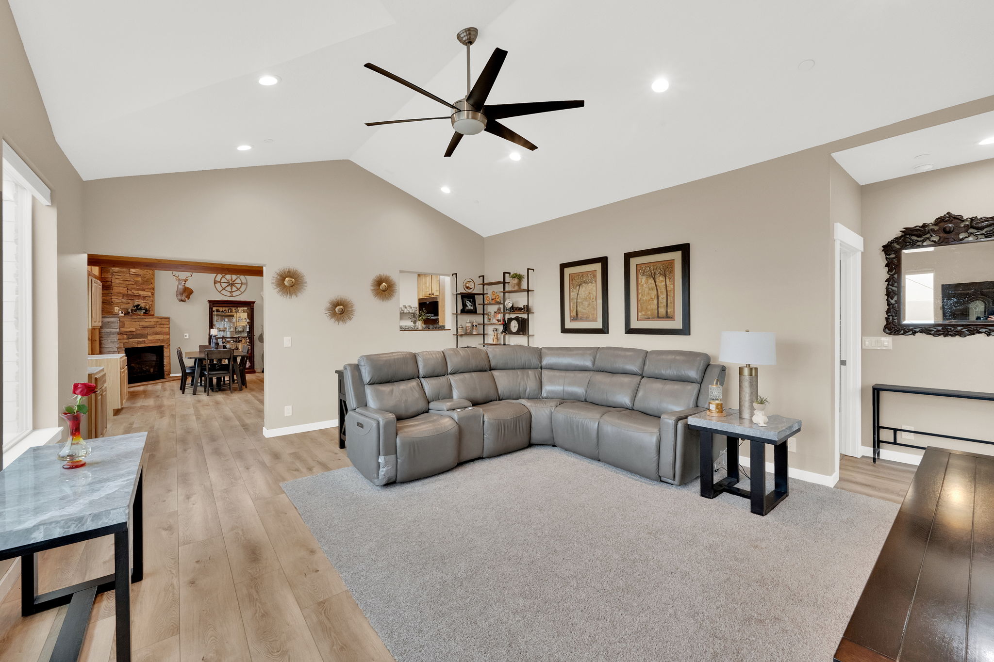 Vaulted ceiling living room featuring a contemporary ceiling fan, recessed lighting, light wood-finish flooring, and a broad area rug