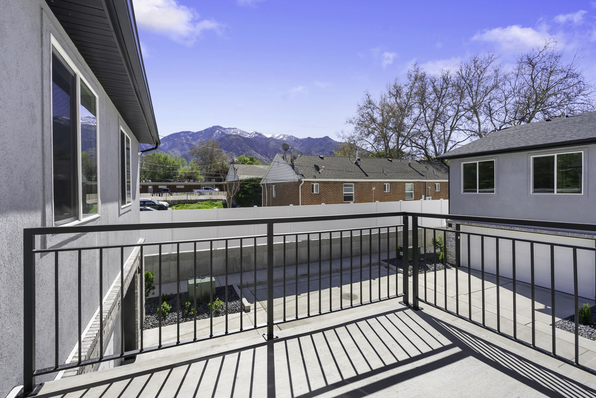 Concrete balcony featuring a black metal railing and mountain scenery
