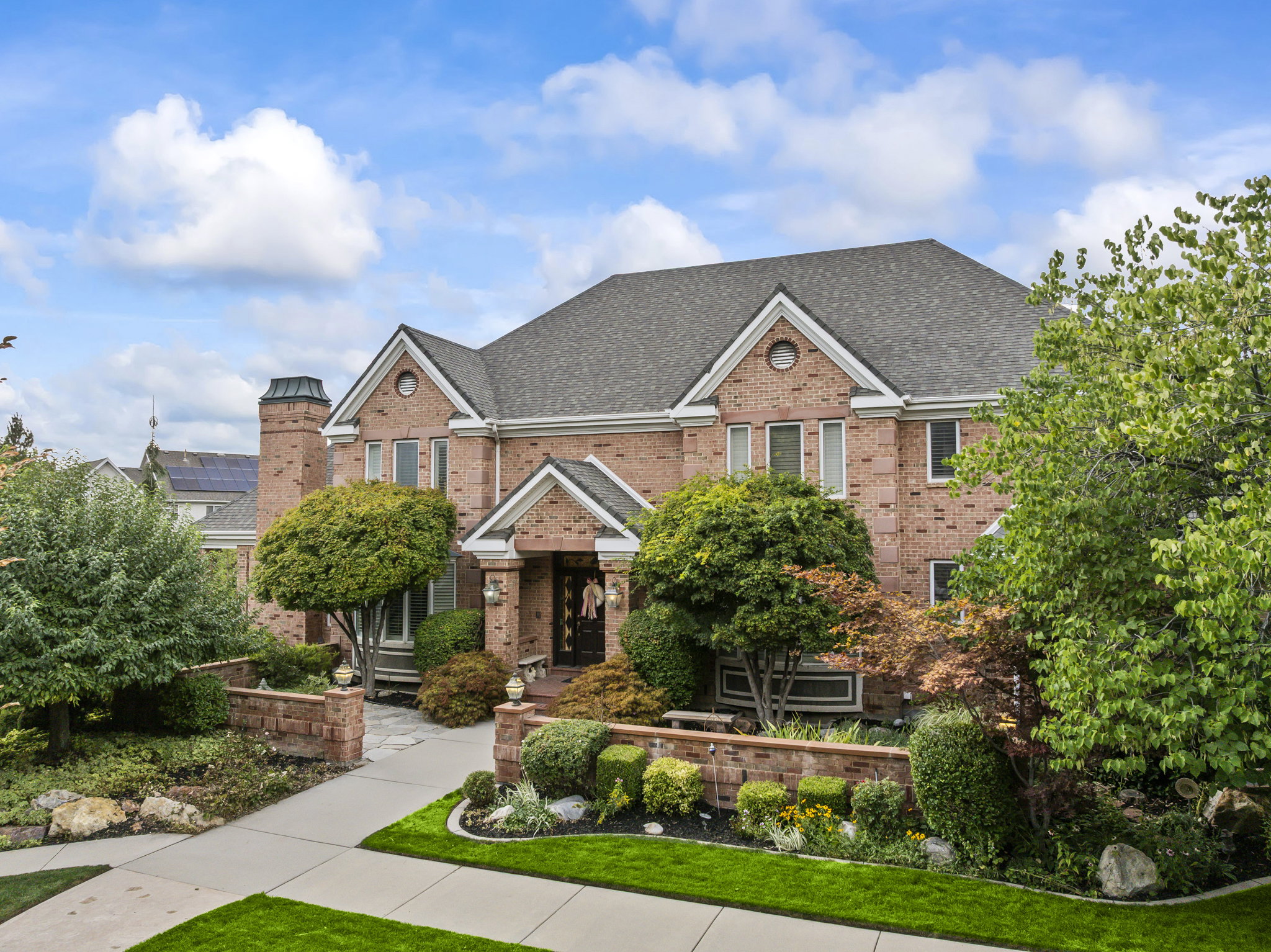 View of front facade featuring brick siding and roof with shingles