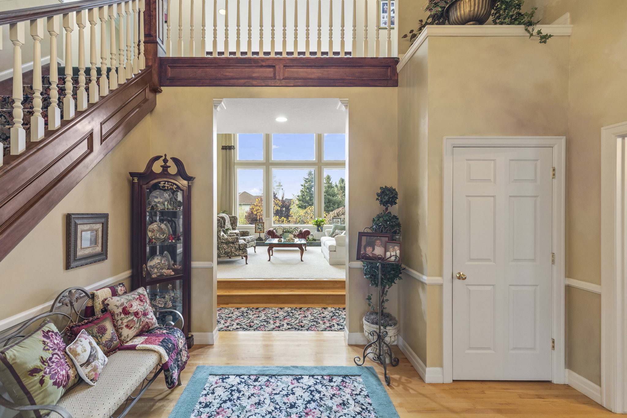 Entrance foyer with light wood-type flooring and a high ceiling