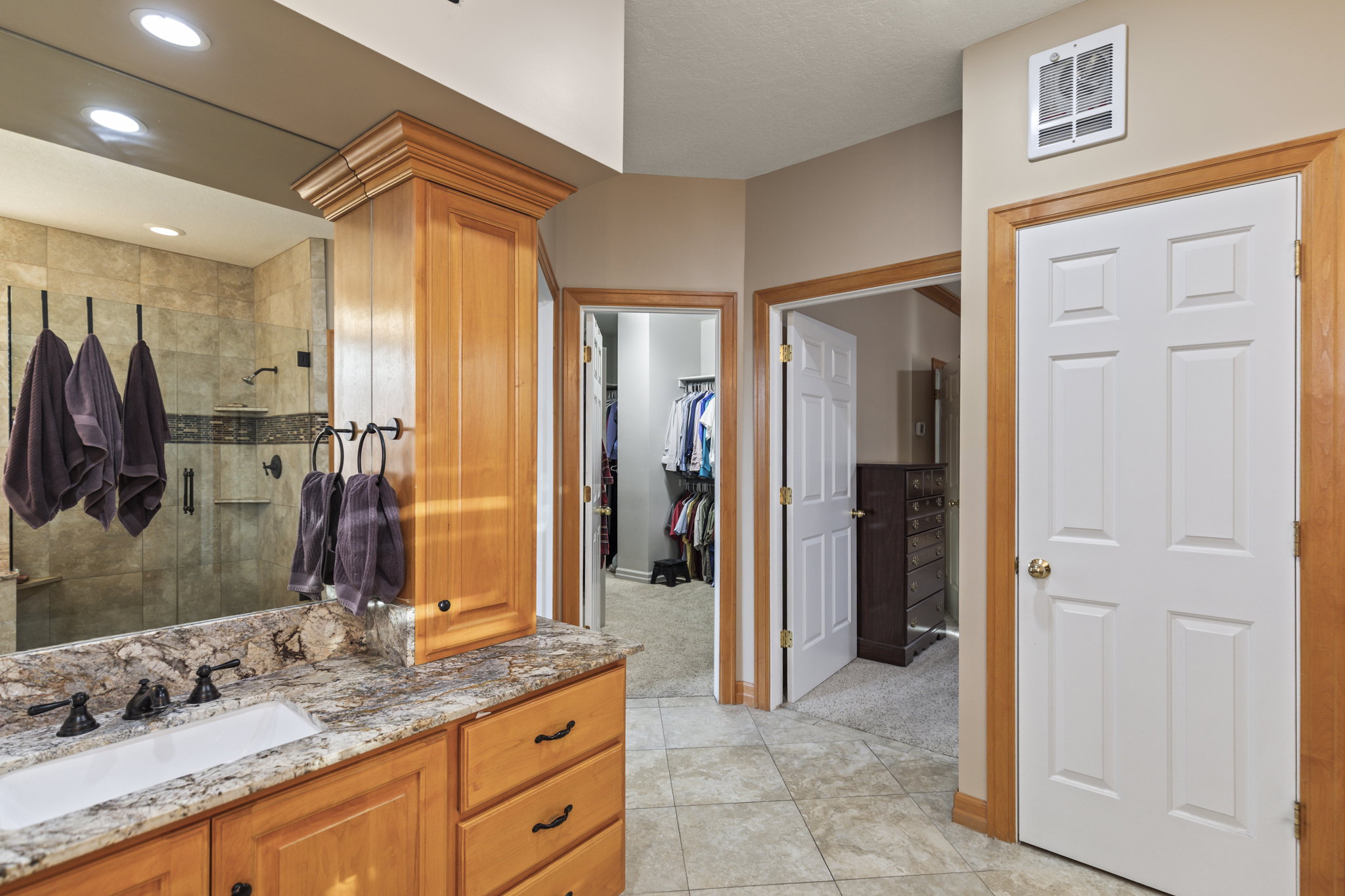 Full bathroom with vanity, a shower stall, a walk in closet, light tile patterned floors, and recessed lighting