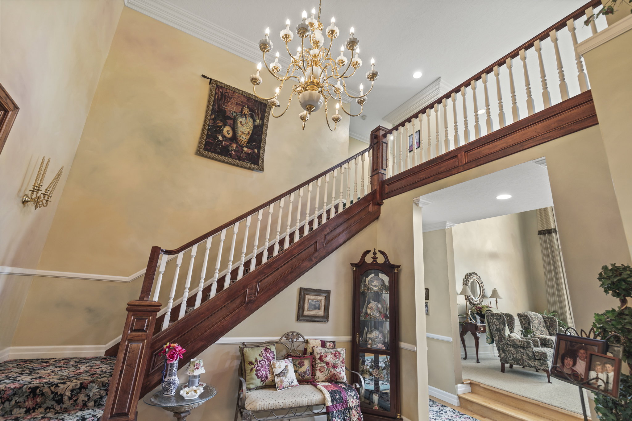 Stairs with ornamental molding, a chandelier, and a high ceiling