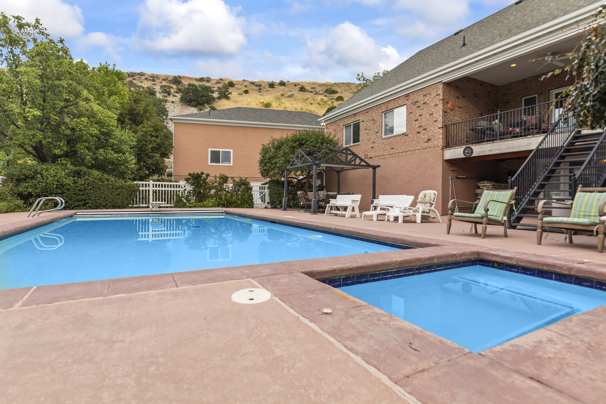 View of swimming pool featuring patio surround and a balcony