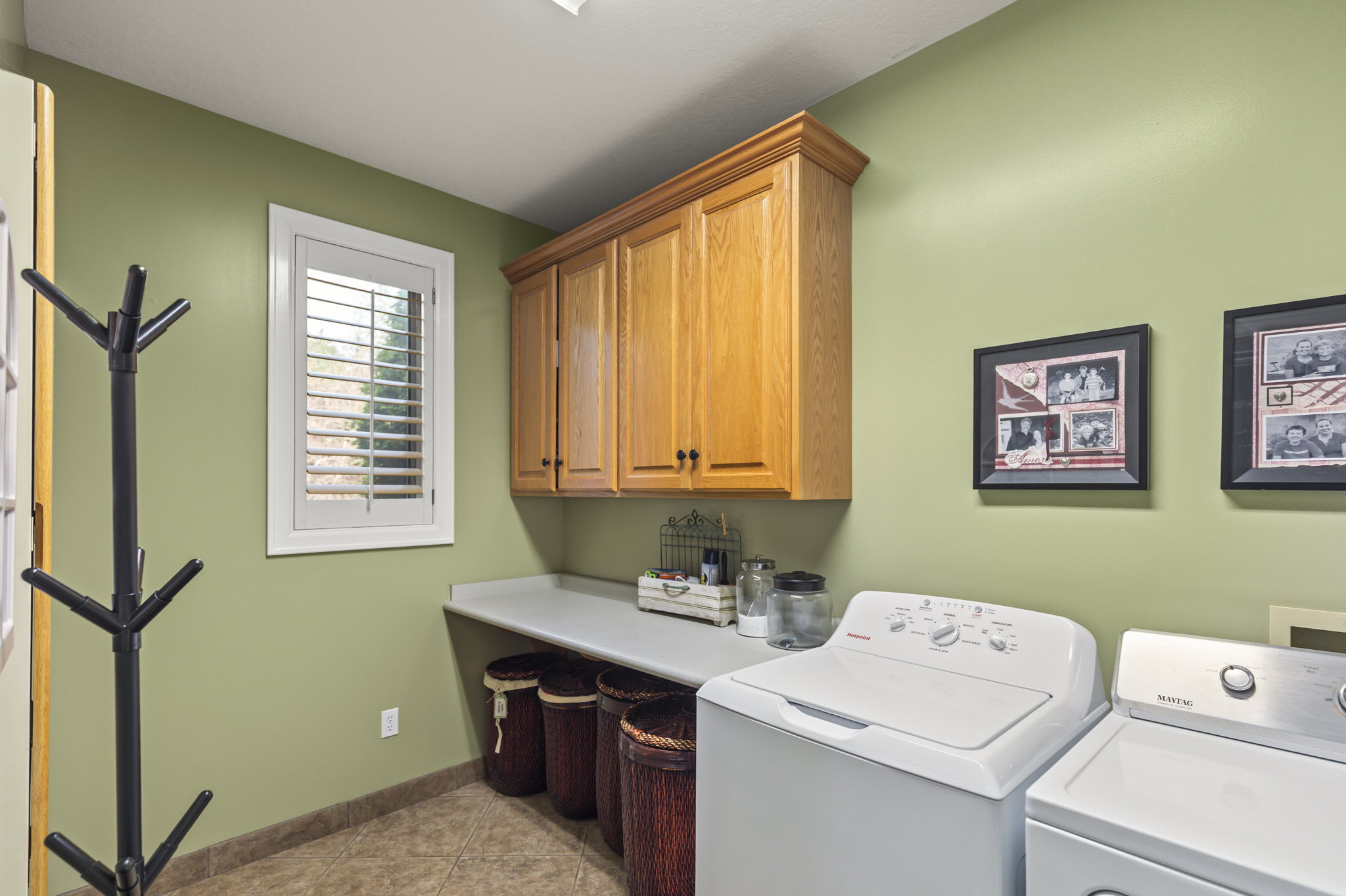 Laundry room featuring independent washer and dryer, light tile patterned flooring, and cabinet space