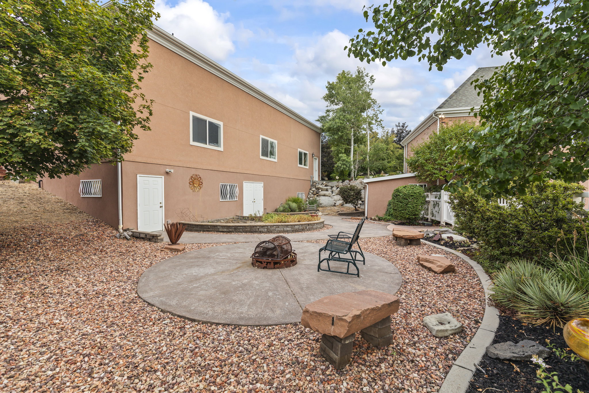Back of house featuring a patio, a fire pit, and stucco siding