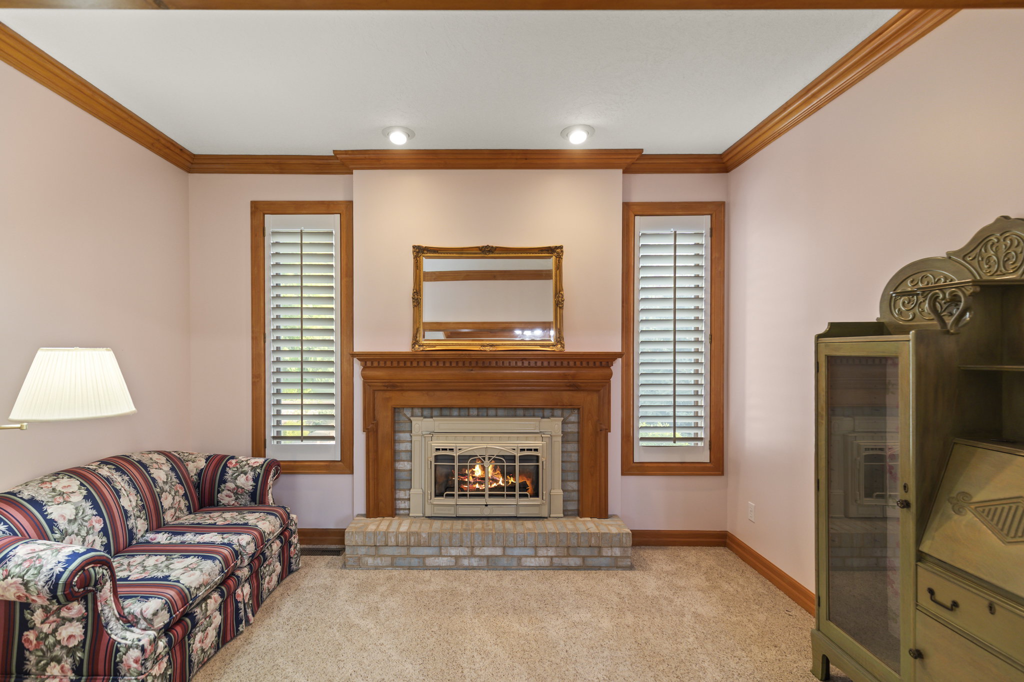 Living area featuring ornamental molding, carpet floors, and a fireplace