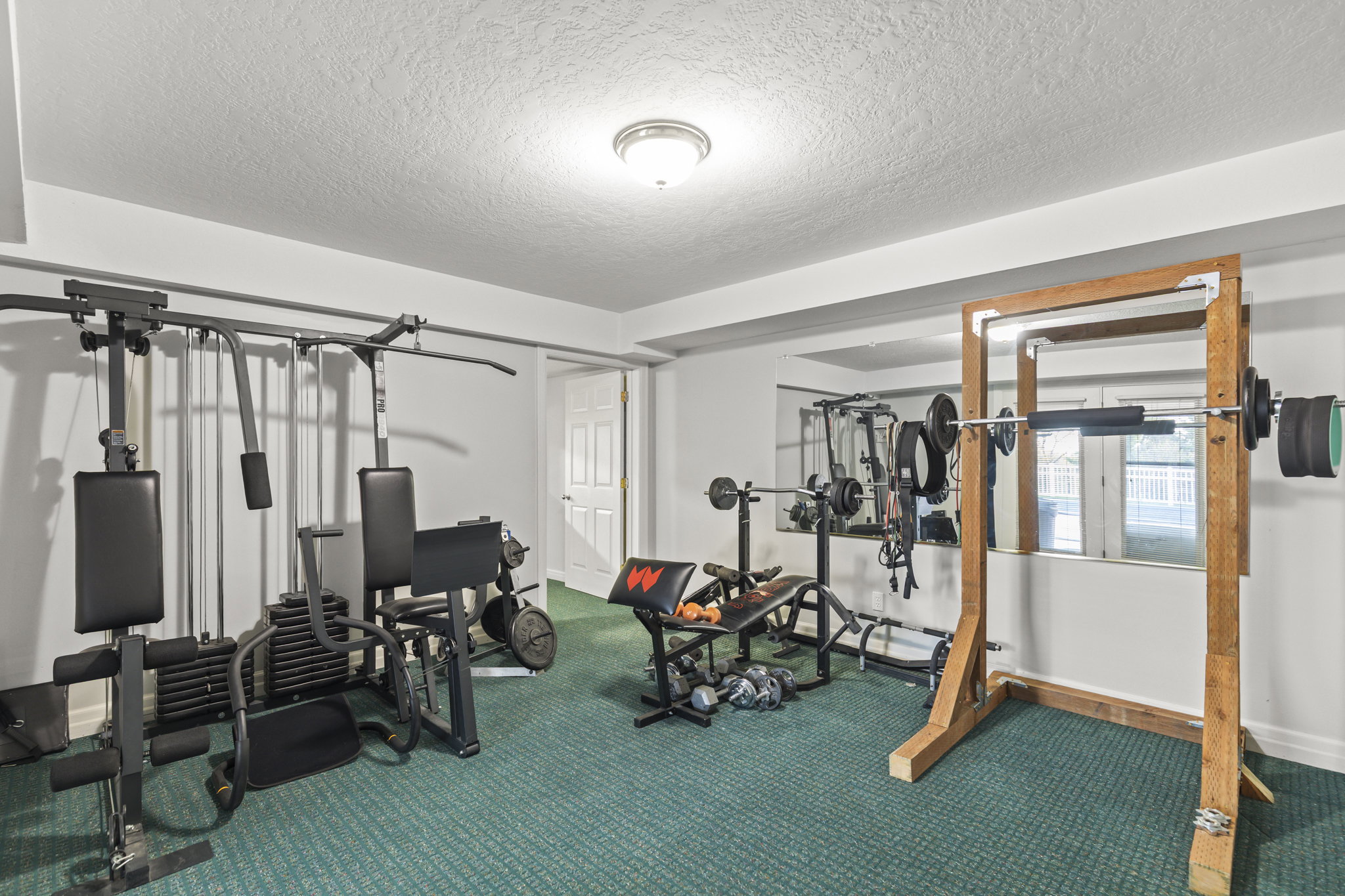 Workout area with a textured ceiling and carpet flooring