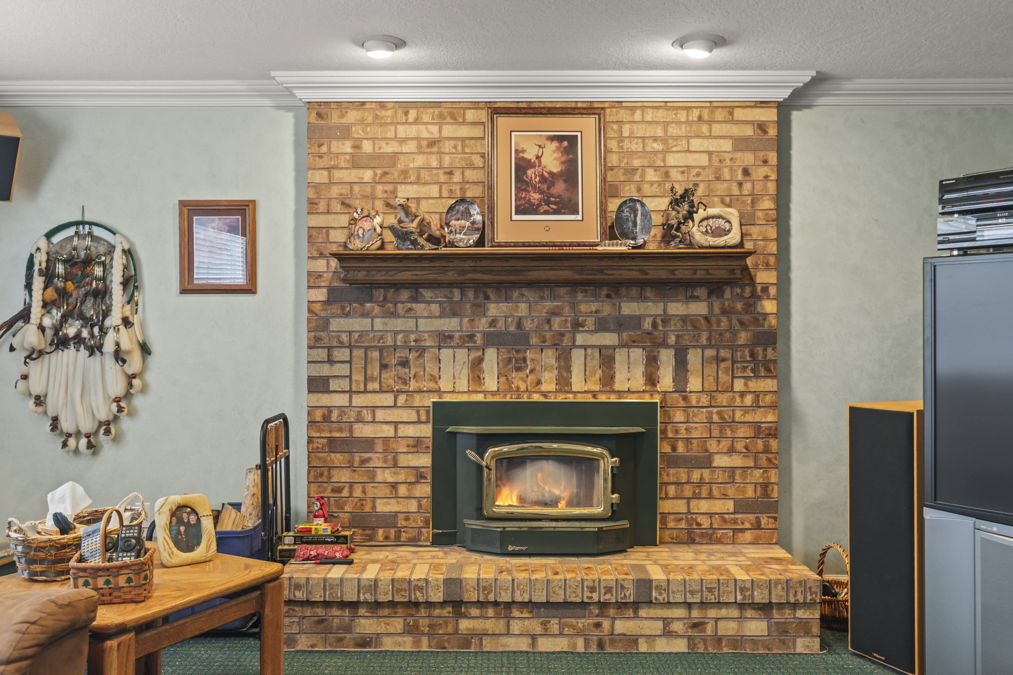 Detailed view of ornamental molding, a wood stove, and carpet flooring