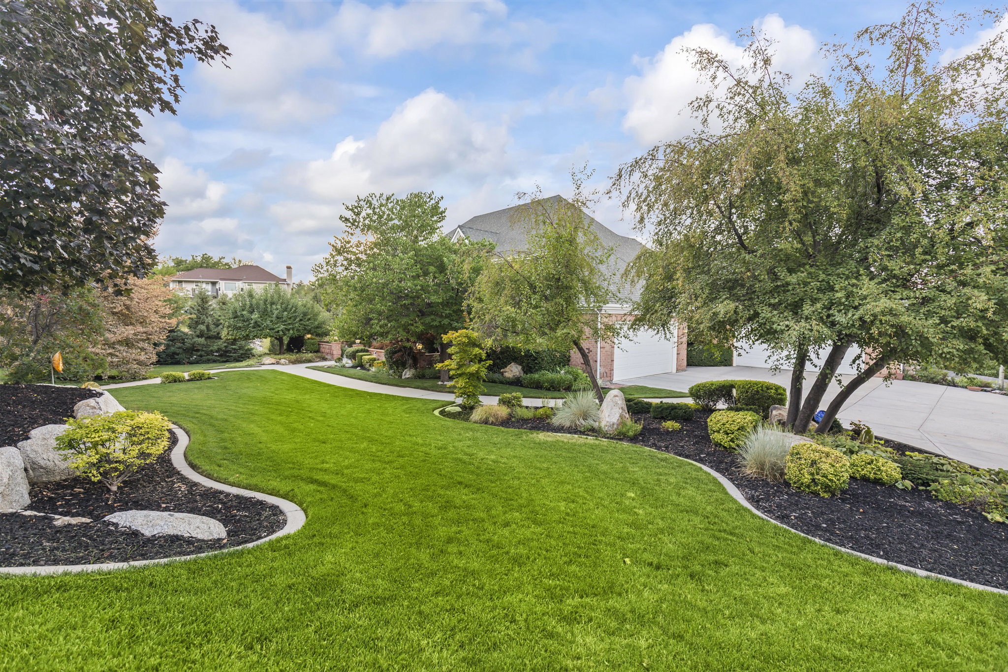 View of green lawn featuring driveway