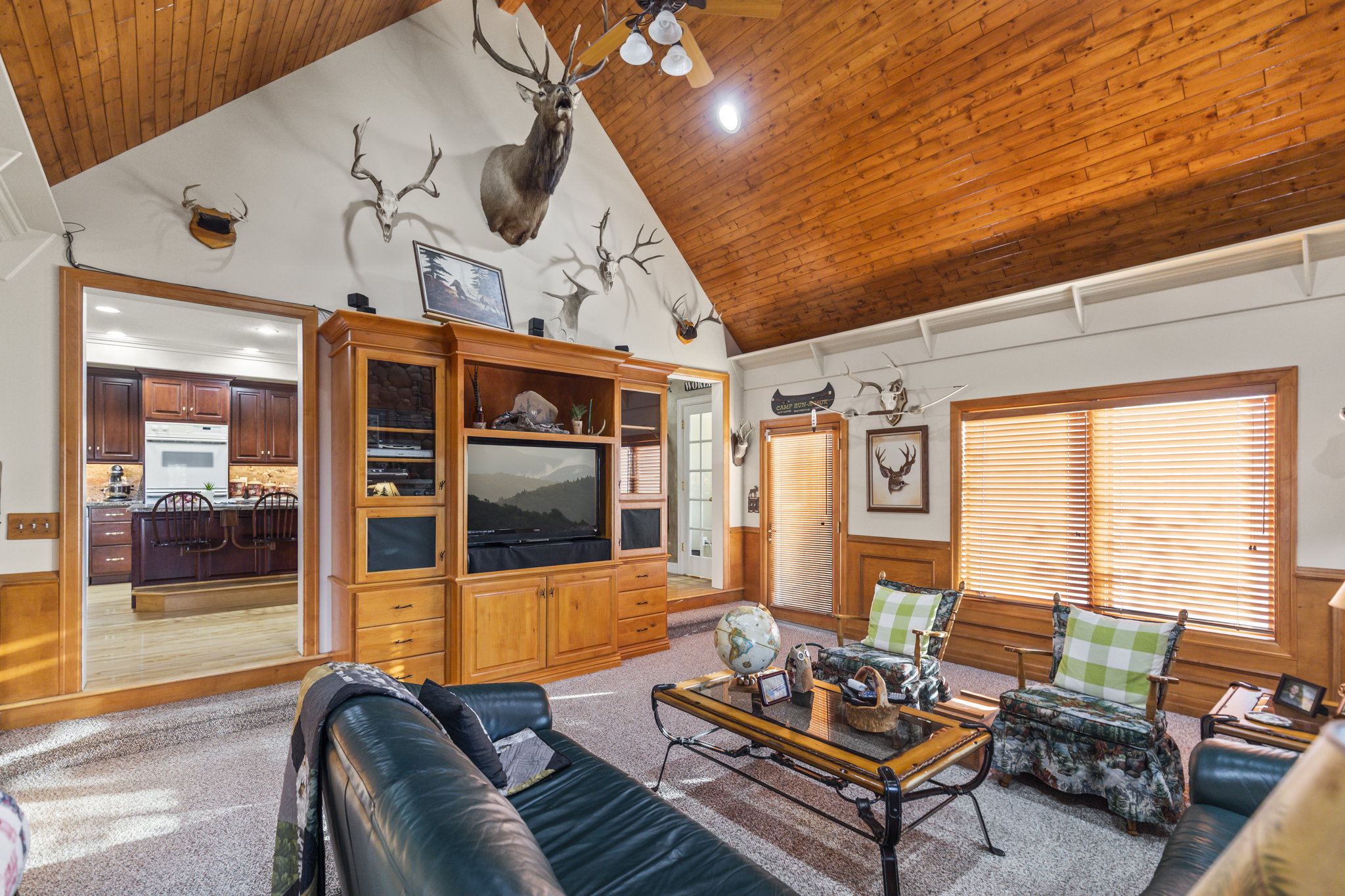 Living room with wainscoting, a vaulted wooden ceiling, wooden walls, recessed lighting, and light colored carpet
