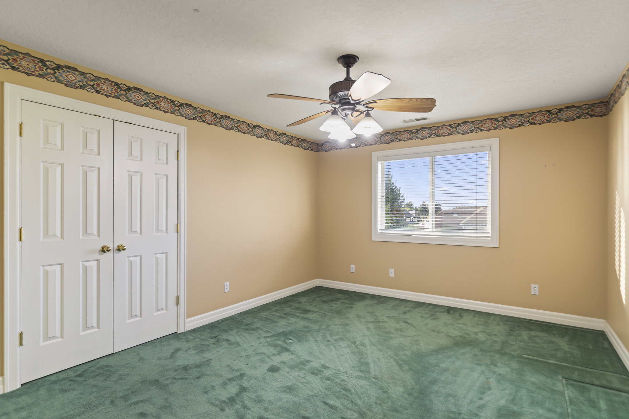 Unfurnished bedroom with carpet, a closet, and a ceiling fan
