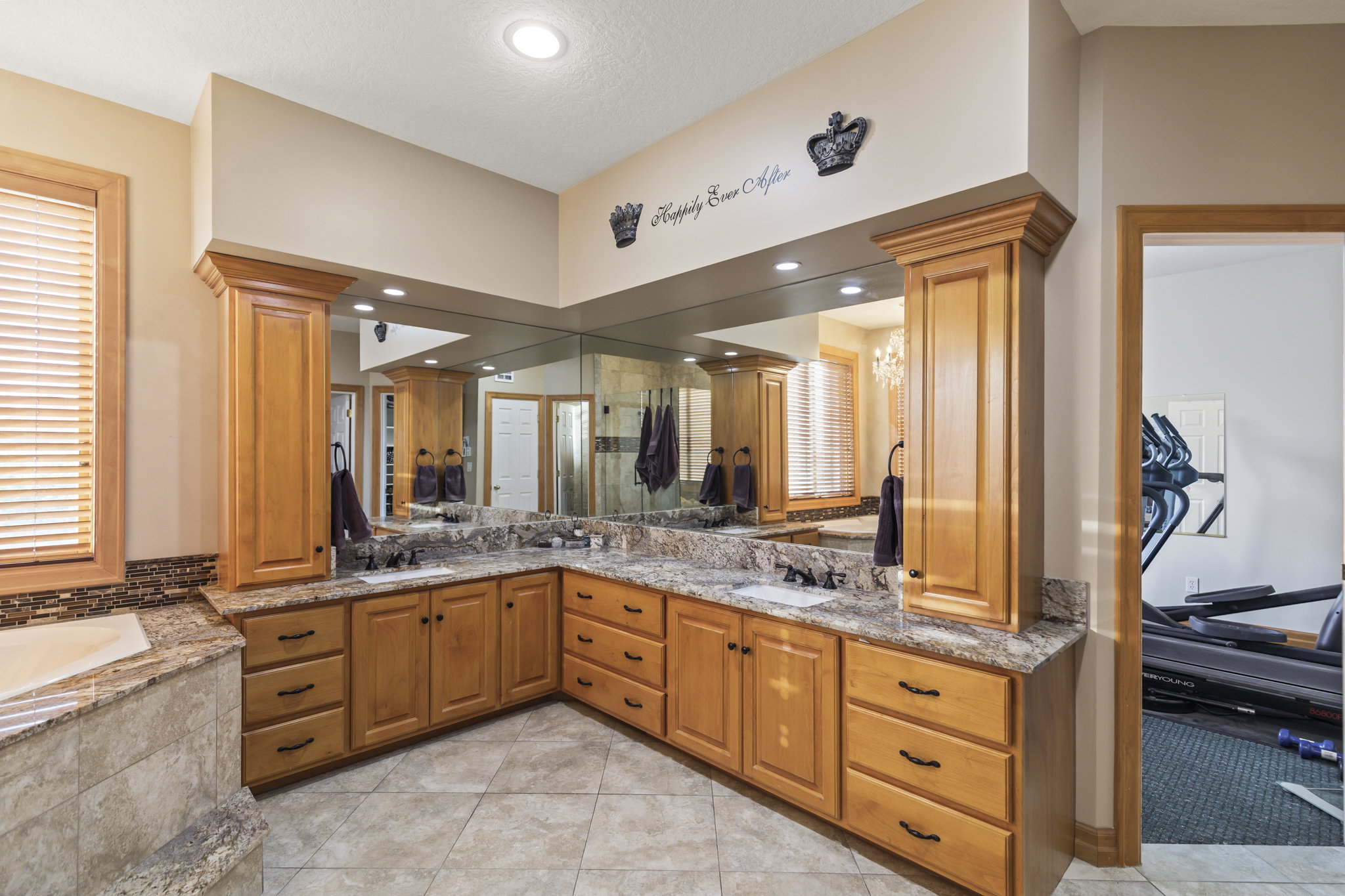 Full bathroom with double vanity, a bath, light tile patterned flooring, and recessed lighting