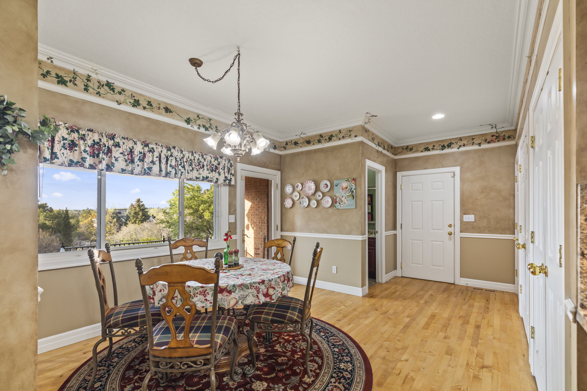 Dining space with light wood-type flooring, a chandelier, and ornamental molding