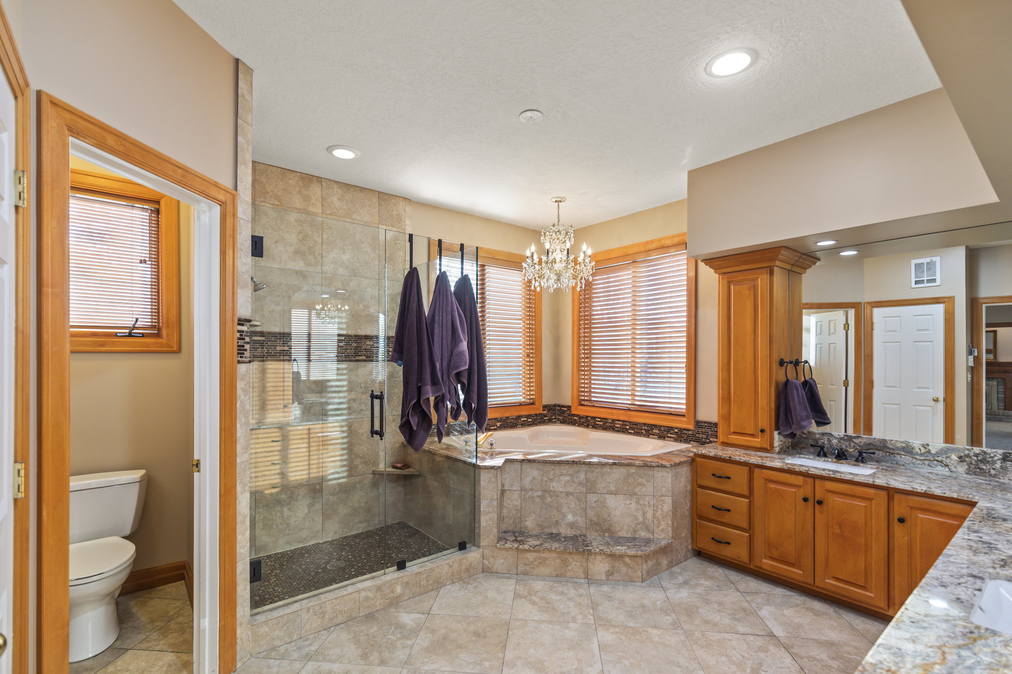 Bathroom with vanity, a stall shower, a garden tub, a chandelier, and light tile patterned floors