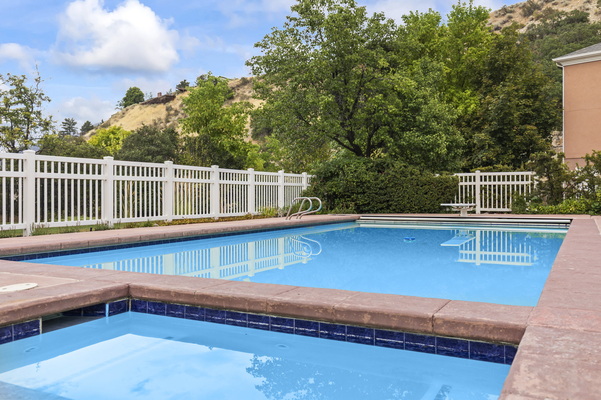 View of swimming pool with an in-ground hot tub, patio surround, and a mountain view