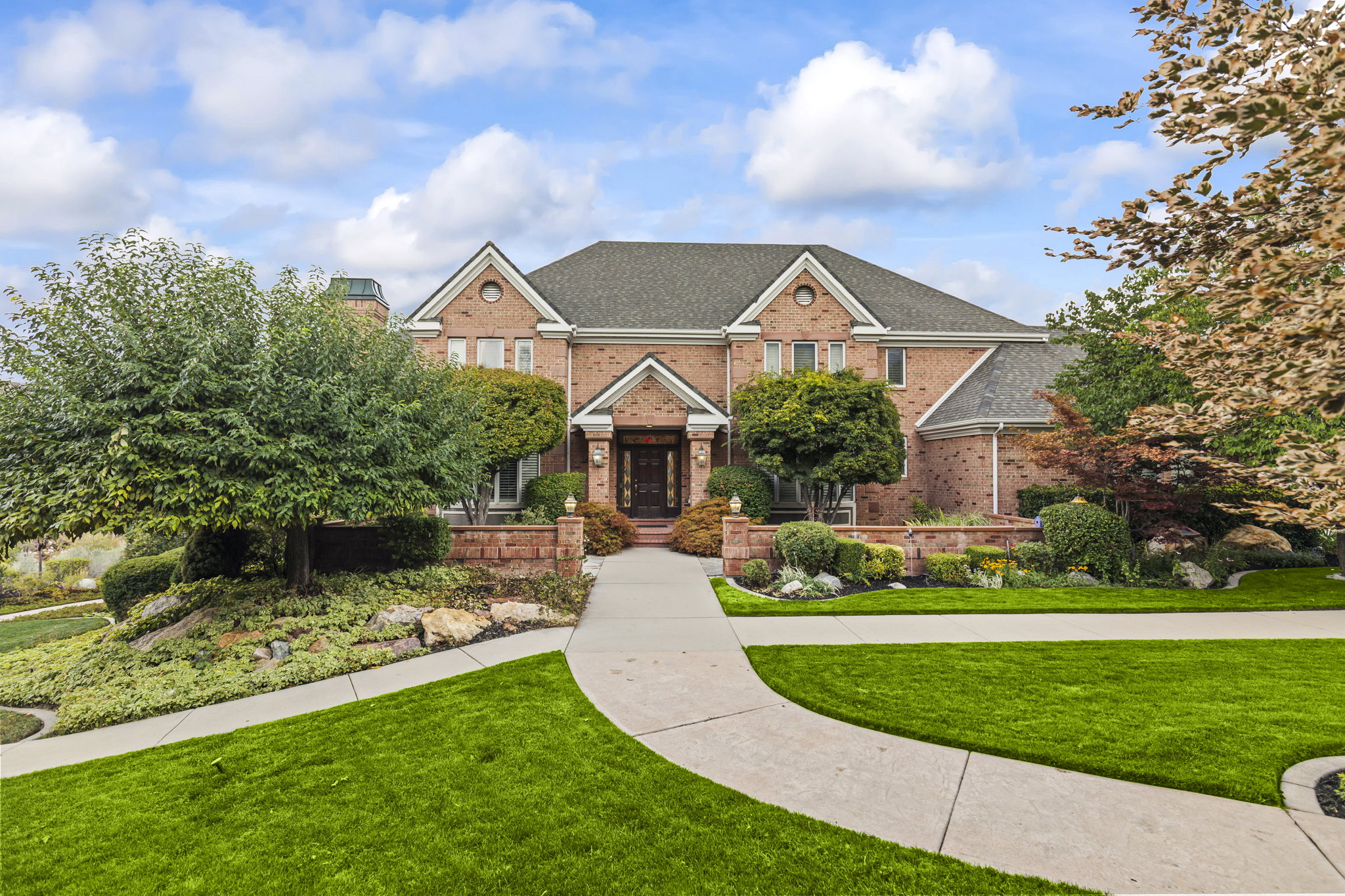 View of front of property featuring a front yard, brick siding, and a shingled roof
