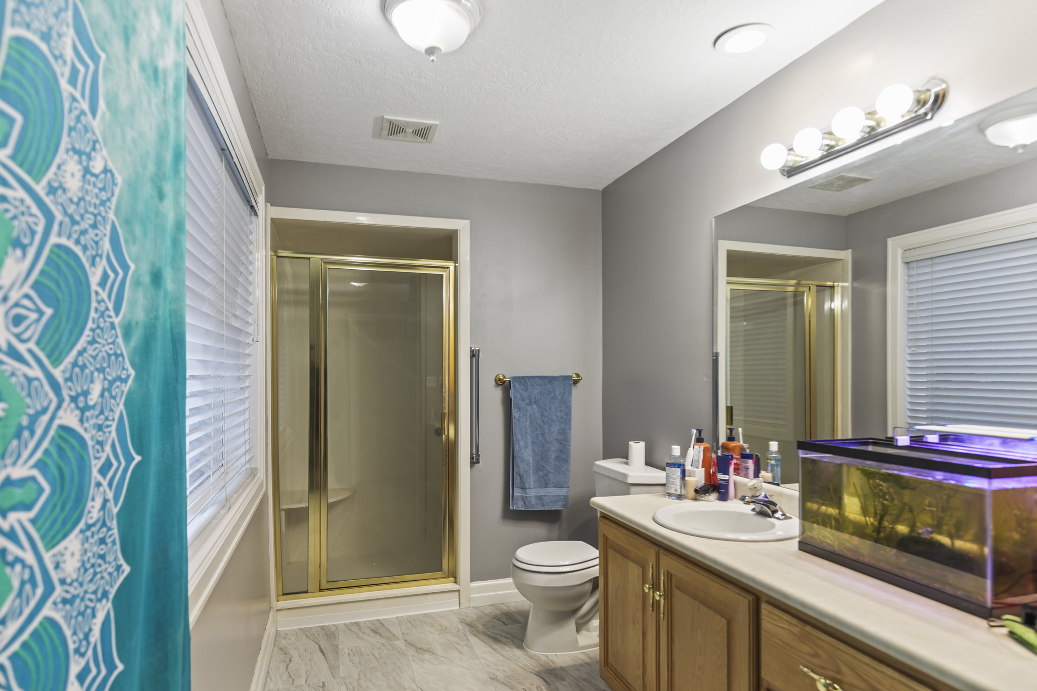 Full bathroom featuring a stall shower, vanity, and light marble finish floors