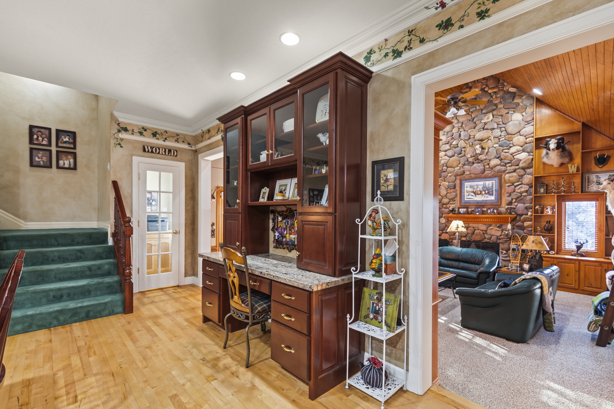 Office space featuring built in study area, a stone fireplace, ornamental molding, light wood-style flooring, and recessed lighting
