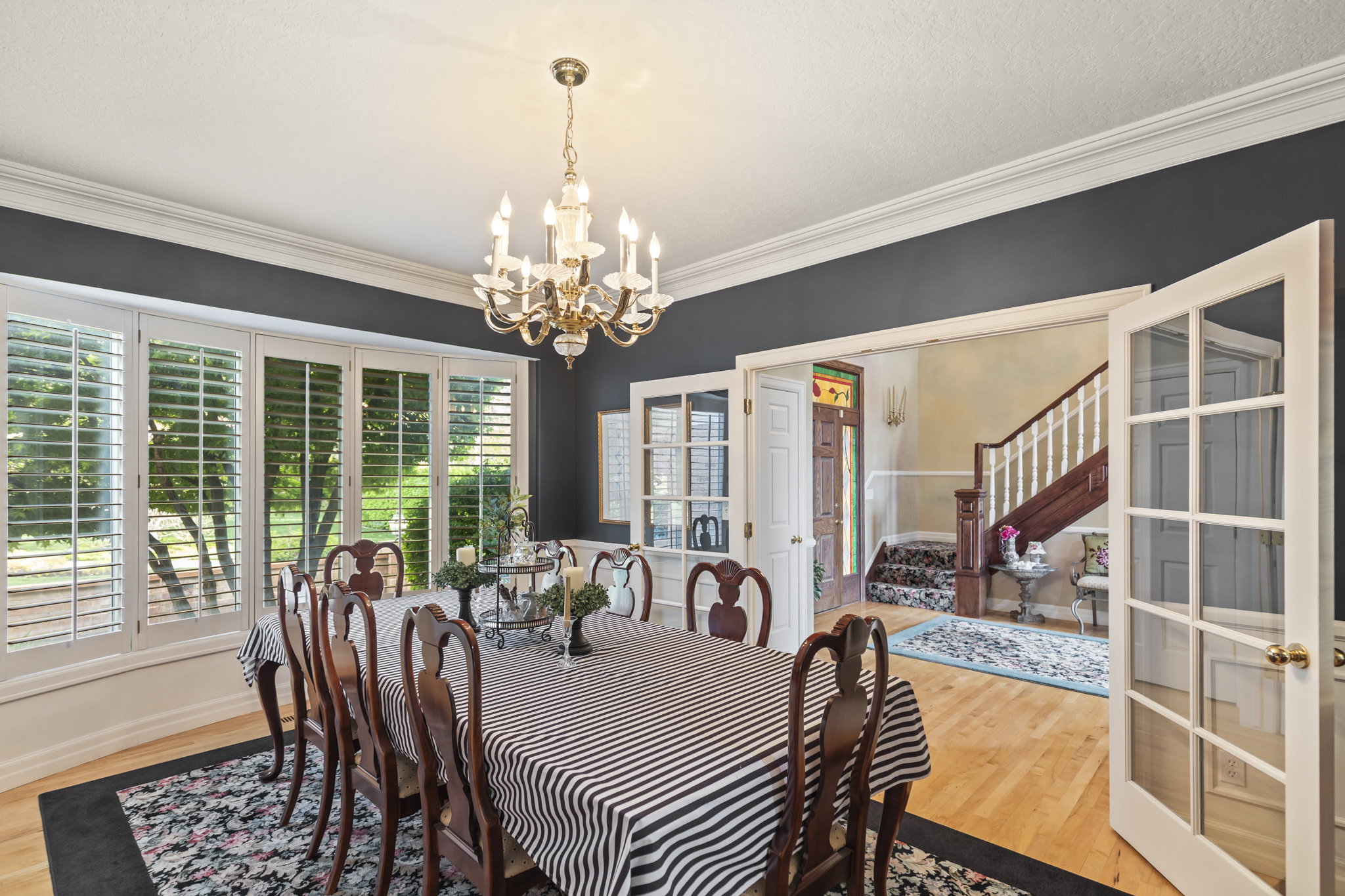 Dining room with light wood-type flooring, crown molding, and hanging lights