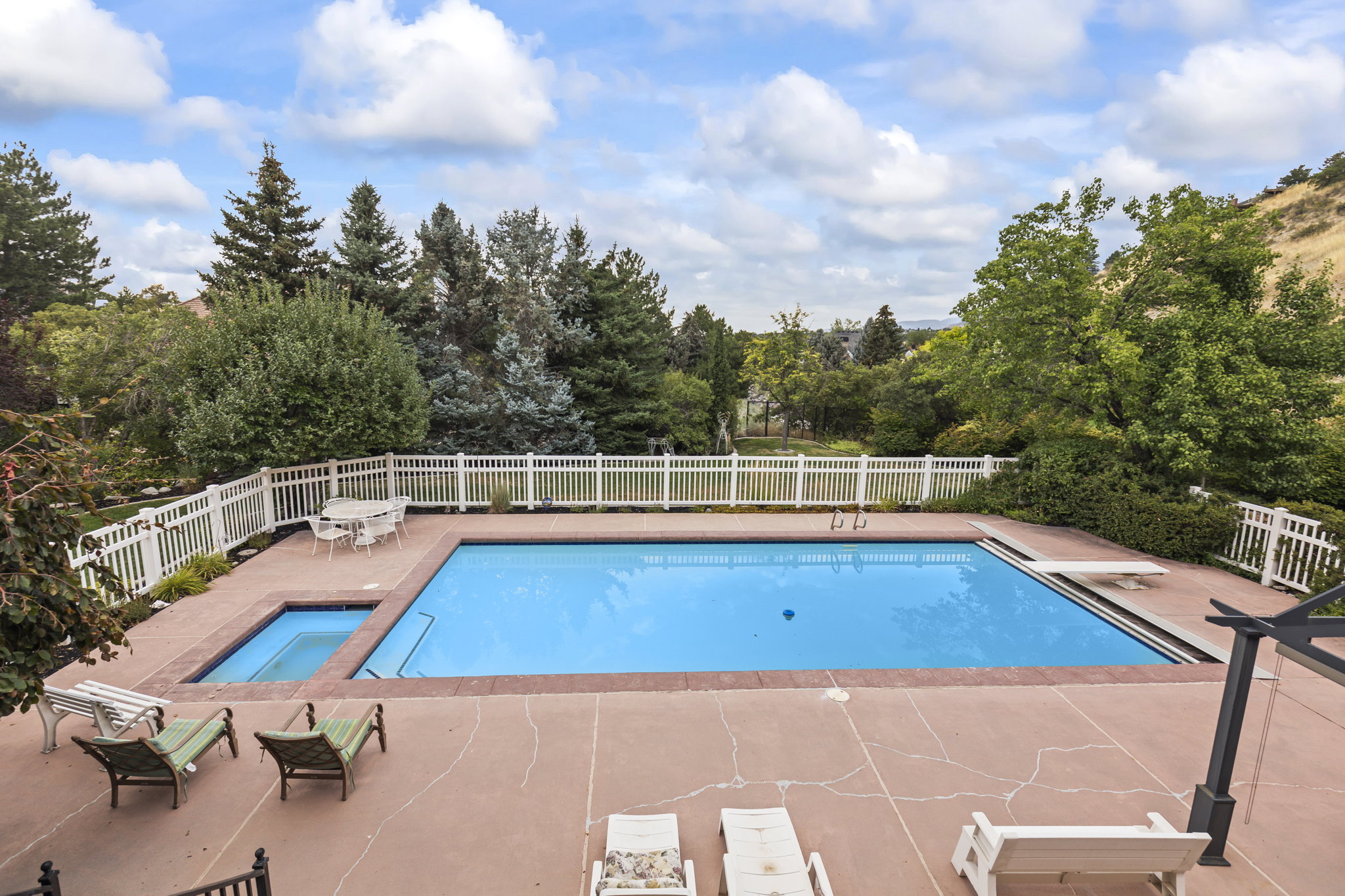 View of pool with patio surround and view of wooded area