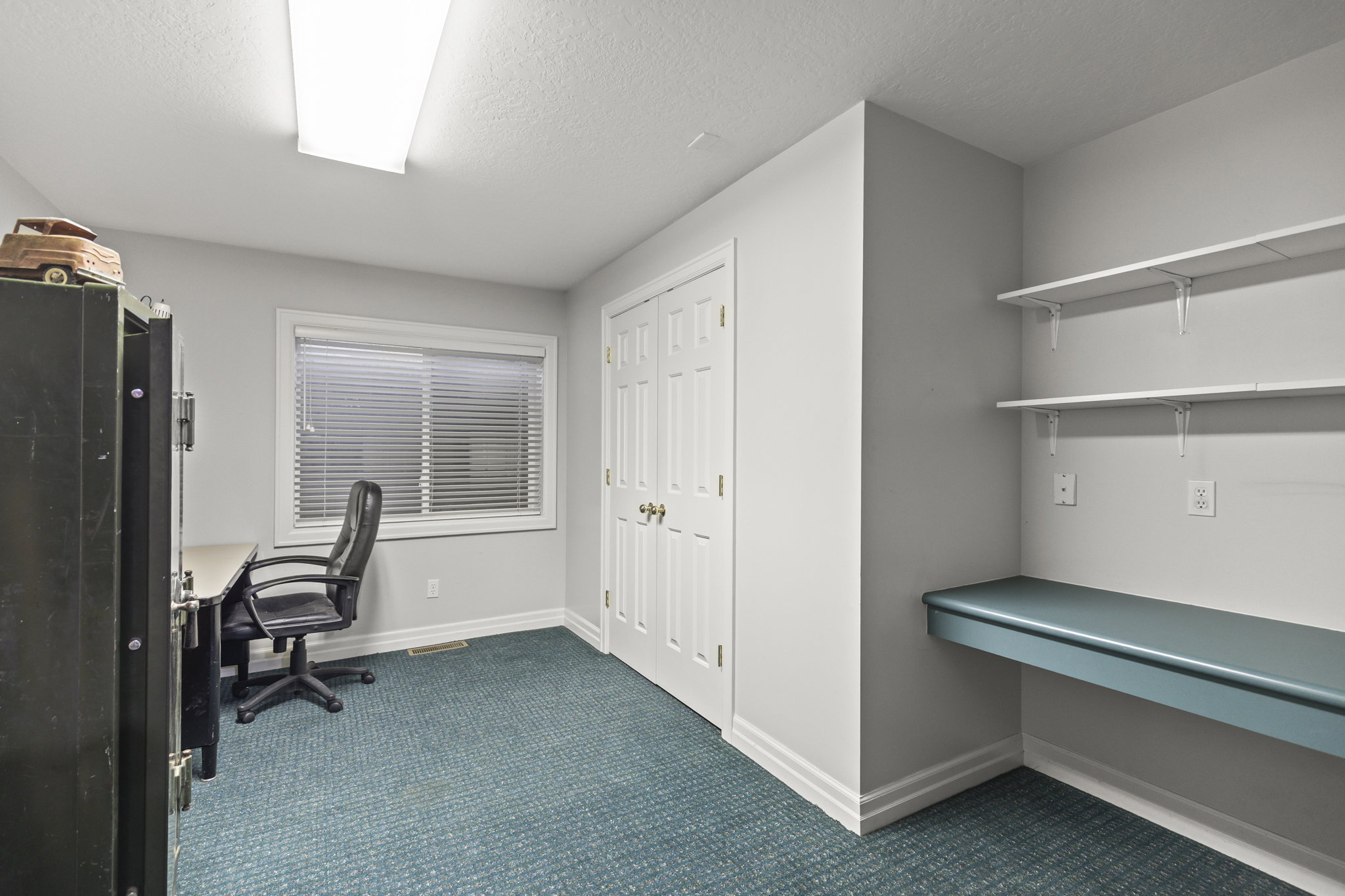 Office area featuring dark carpet and a textured ceiling