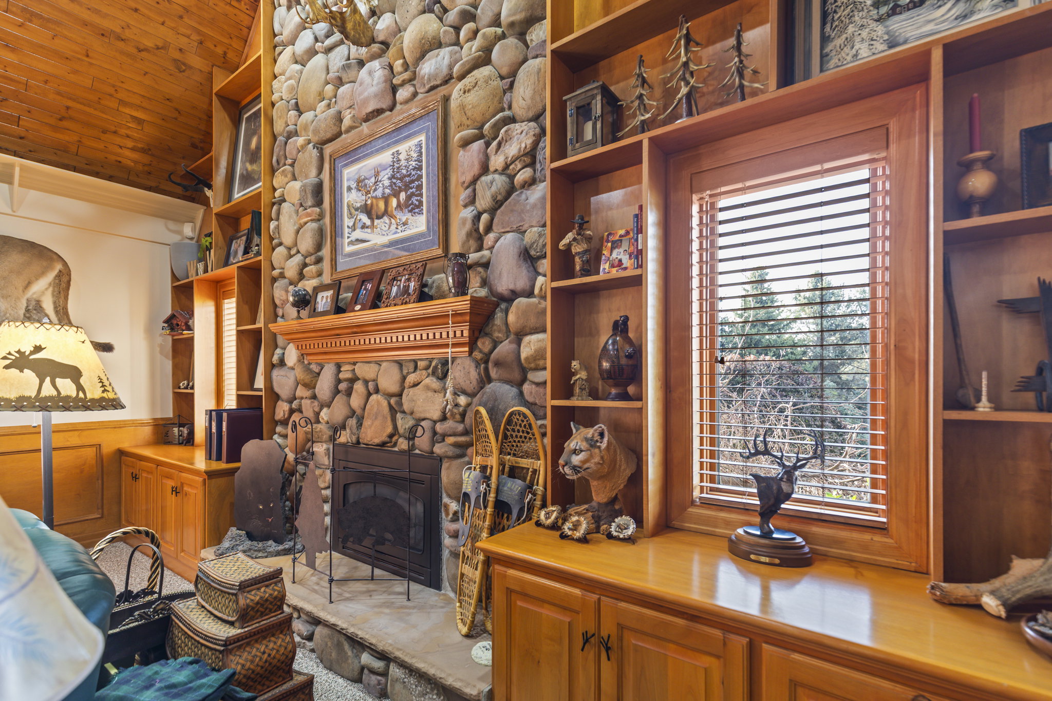 Living room with built in shelves, a fireplace, and wooden ceiling