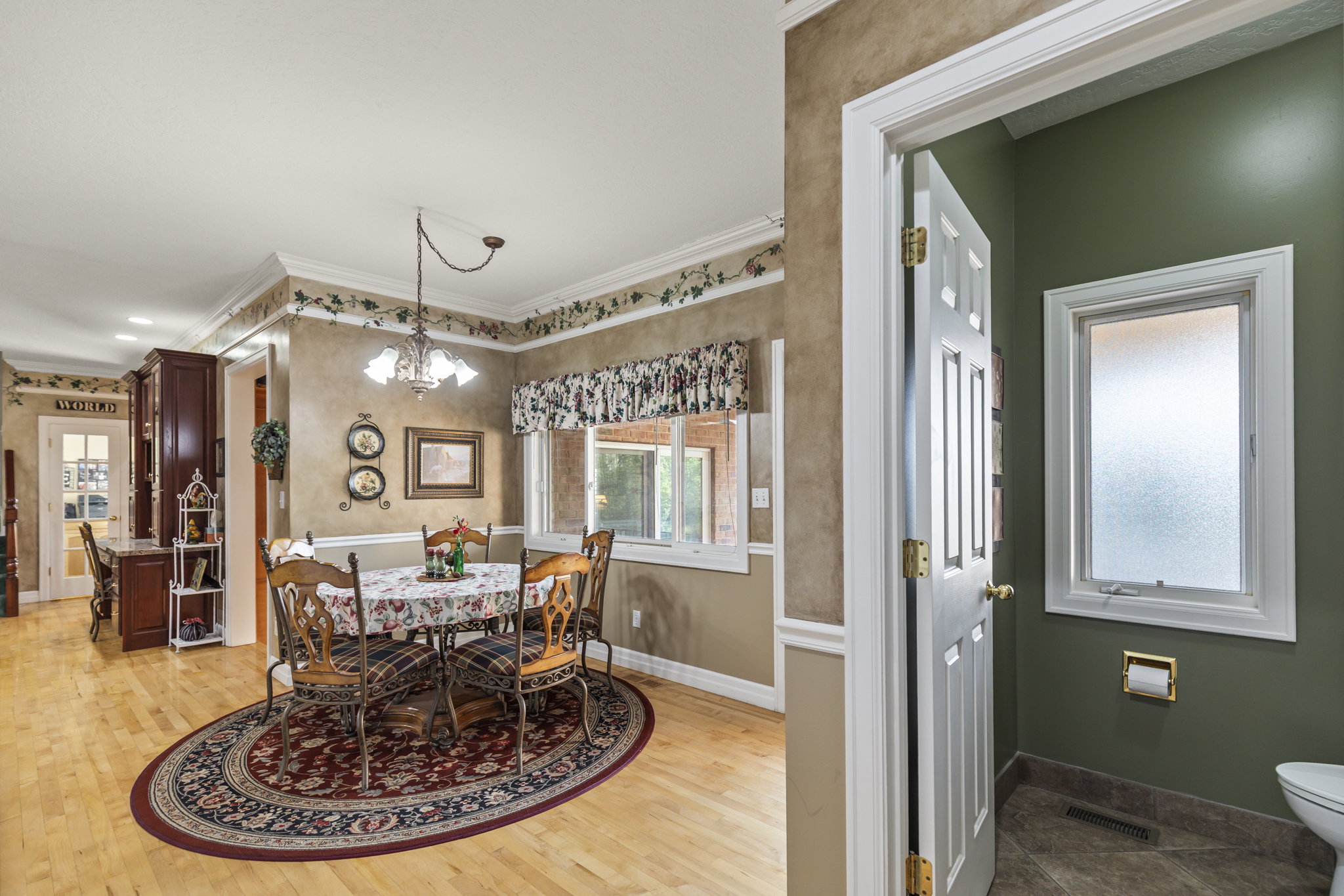 Dining space featuring hanging lights, ornamental molding, and light wood-style floors